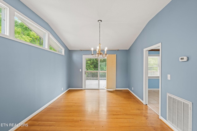 unfurnished dining area with light wood-type flooring, lofted ceiling, and an inviting chandelier