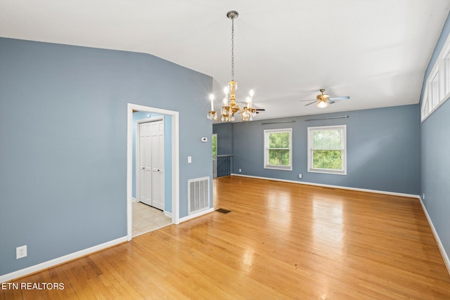 unfurnished room with lofted ceiling, ceiling fan with notable chandelier, and light hardwood / wood-style floors