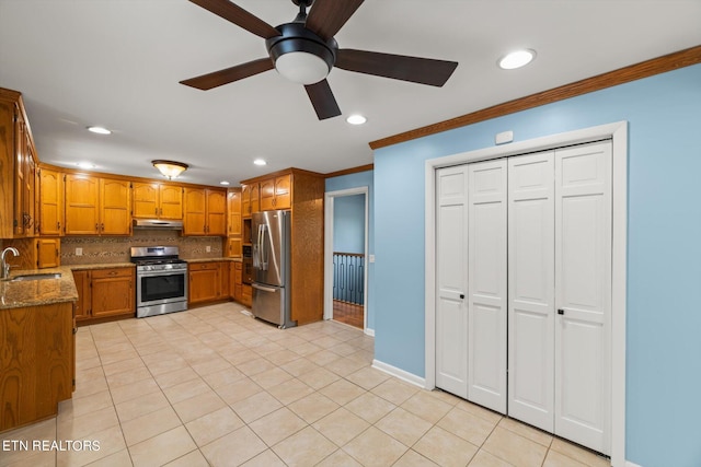 kitchen featuring tasteful backsplash, crown molding, stainless steel appliances, sink, and ceiling fan