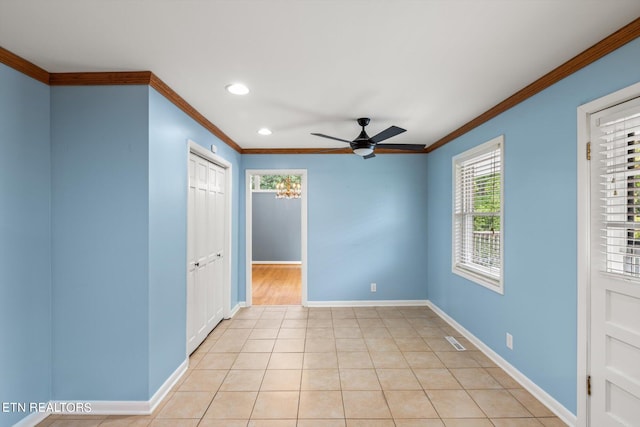 unfurnished bedroom with crown molding, light tile patterned floors, and ceiling fan