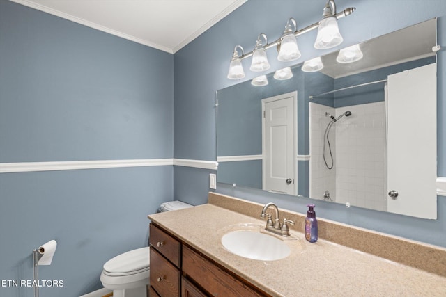 bathroom featuring tiled shower, vanity, toilet, and ornamental molding