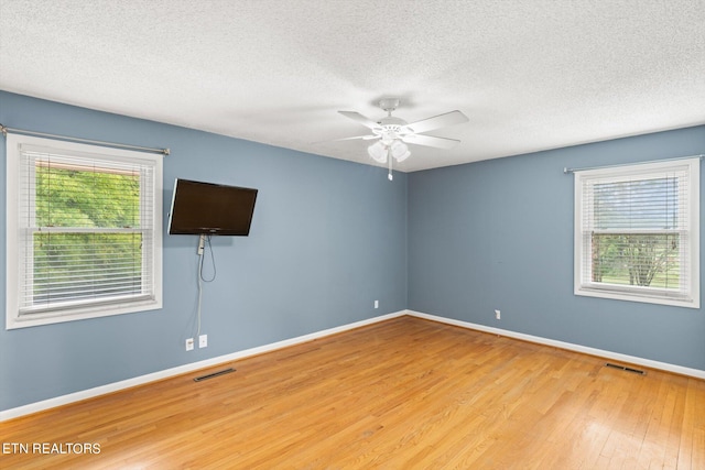 empty room featuring a textured ceiling, ceiling fan, and wood-type flooring