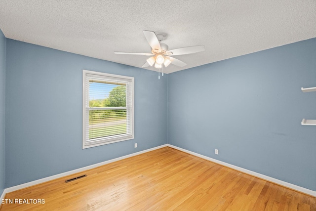 spare room with a textured ceiling, wood-type flooring, and ceiling fan