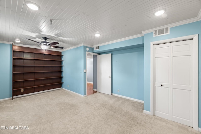 unfurnished bedroom featuring ornamental molding, carpet, ceiling fan, a closet, and wooden ceiling