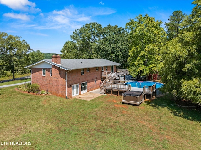 rear view of property featuring a lawn and a wooden deck