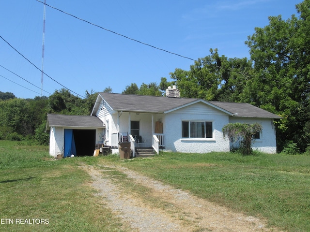 10827 Rutledge Pike, Blaine, TN 37709 - view of front facade with a front lawn, dirt driveway, covered porch, an outdoor structure, and a chimney