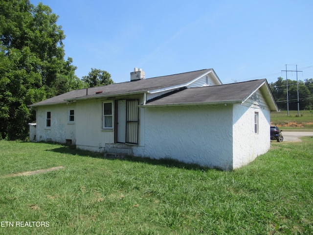 back of property with a lawn