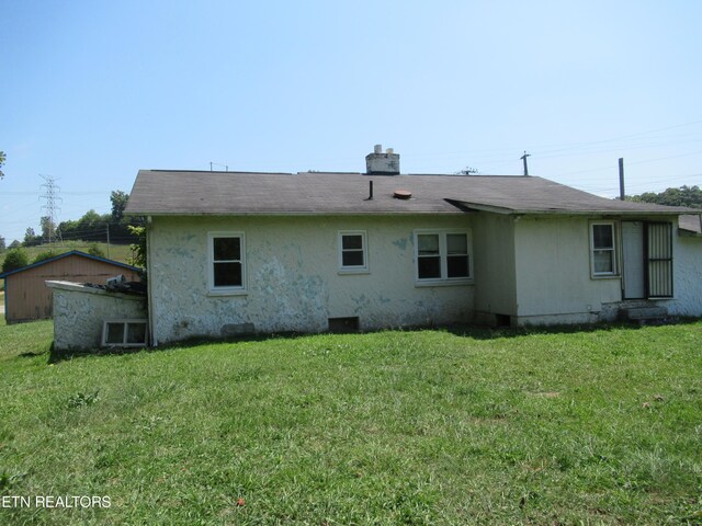 back of property featuring a yard