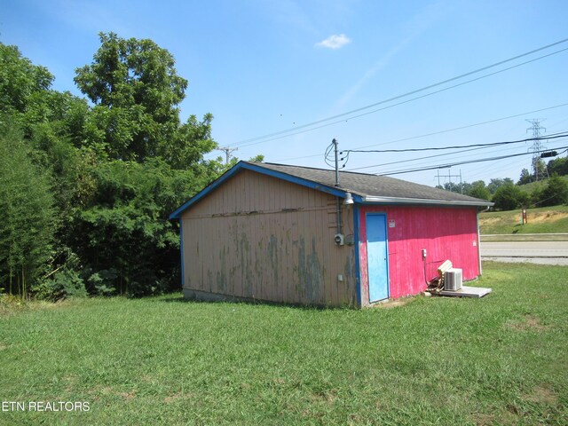 view of outdoor structure with a yard and central AC unit