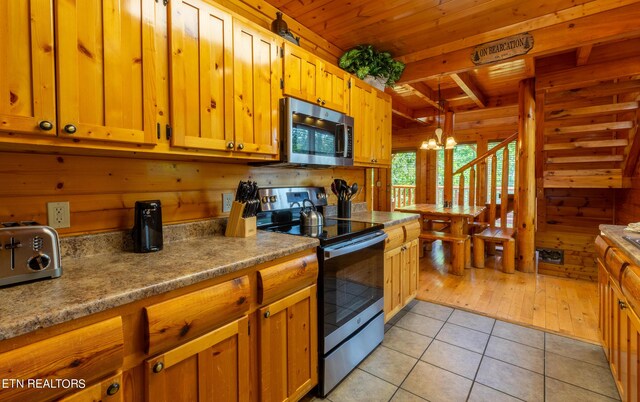 kitchen featuring an inviting chandelier, beamed ceiling, wooden ceiling, stainless steel appliances, and light wood-type flooring