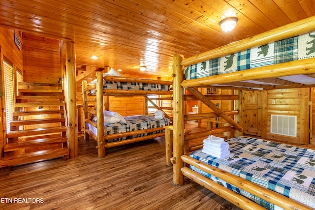 bedroom with wood-type flooring, wood ceiling, and wooden walls