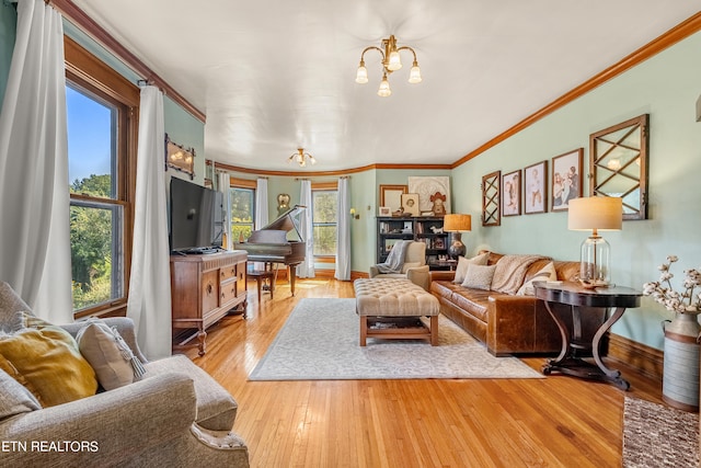 living room featuring crown molding, a chandelier, and light hardwood / wood-style floors