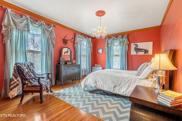 bedroom with hardwood / wood-style floors, a chandelier, and crown molding