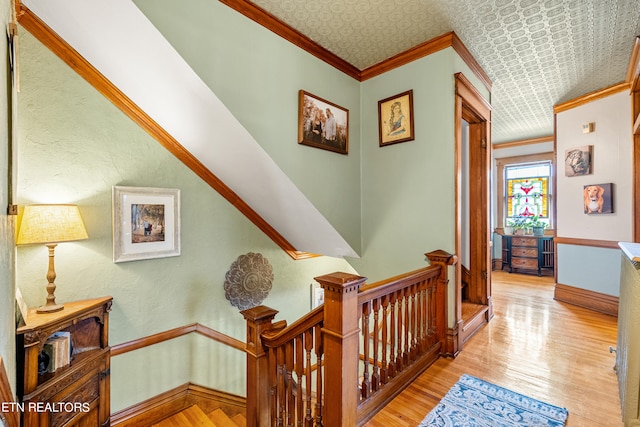 stairs with crown molding and wood-type flooring