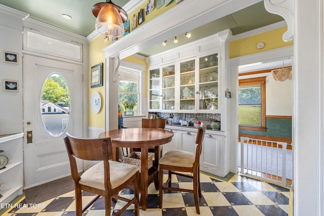 dining space with ornamental molding and a healthy amount of sunlight