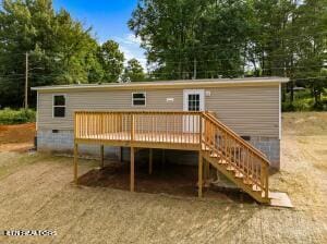 rear view of property with crawl space, a wooden deck, and stairs