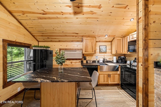 kitchen featuring a kitchen breakfast bar, black appliances, vaulted ceiling, and sink