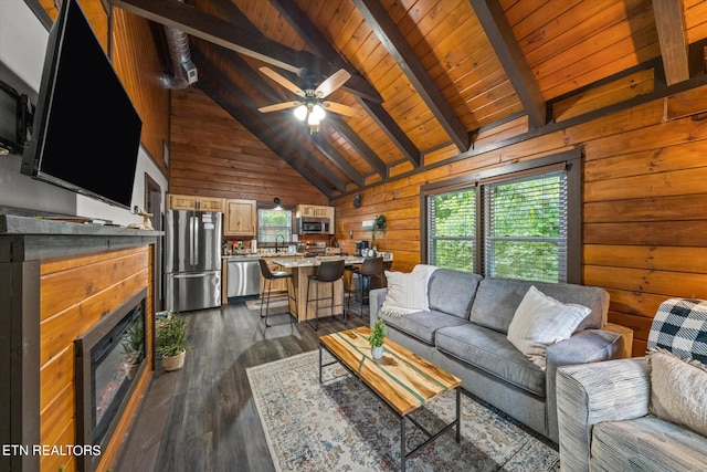 living room featuring a wealth of natural light, ceiling fan, dark hardwood / wood-style floors, and wooden walls