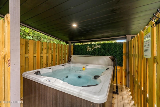 wooden deck featuring a hot tub