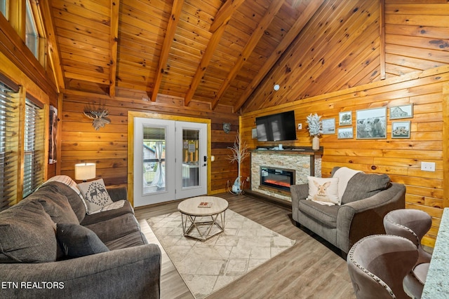 living room with wood ceiling, light wood-type flooring, beamed ceiling, a fireplace, and wooden walls