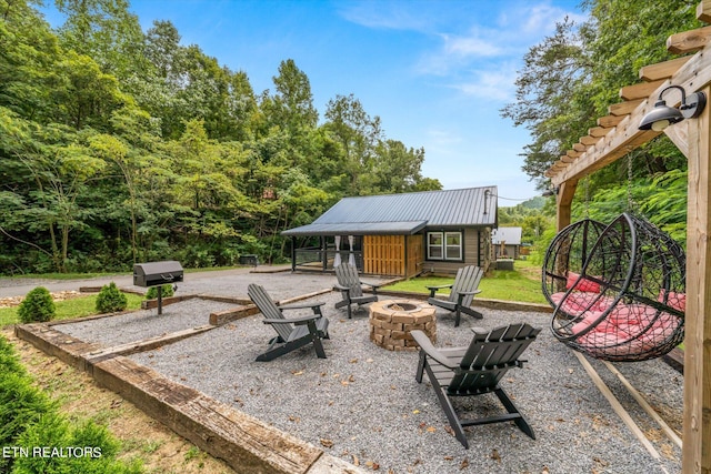 view of patio / terrace with a fire pit and an outbuilding