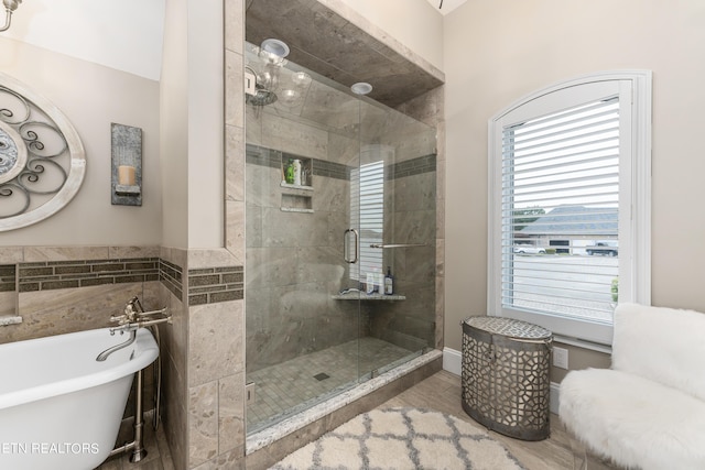 bathroom featuring a wealth of natural light, wood-type flooring, and shower with separate bathtub