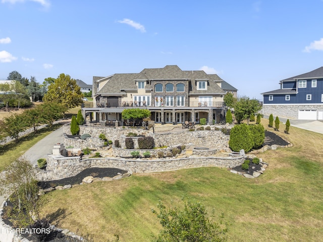 back of house featuring a patio area, a balcony, and a yard