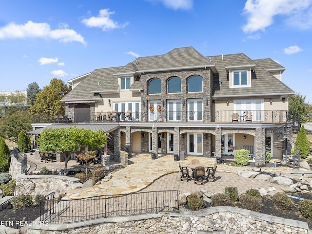 back of house with french doors, a balcony, and a patio area