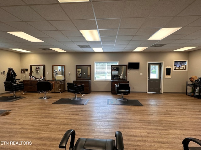 exercise room with a healthy amount of sunlight, light wood-type flooring, and a drop ceiling