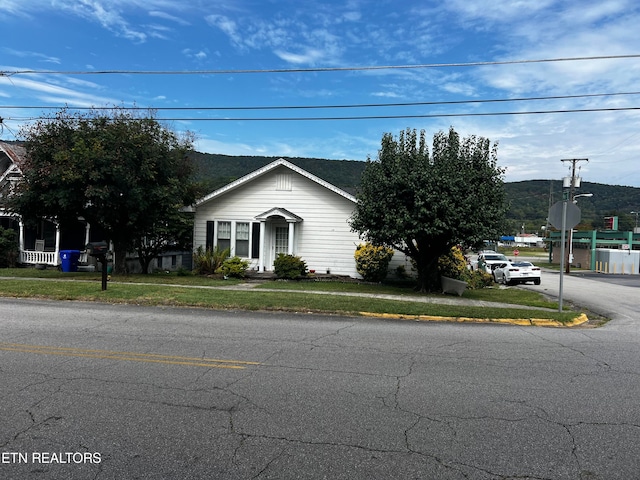 view of front of home with a front lawn and a mountain view