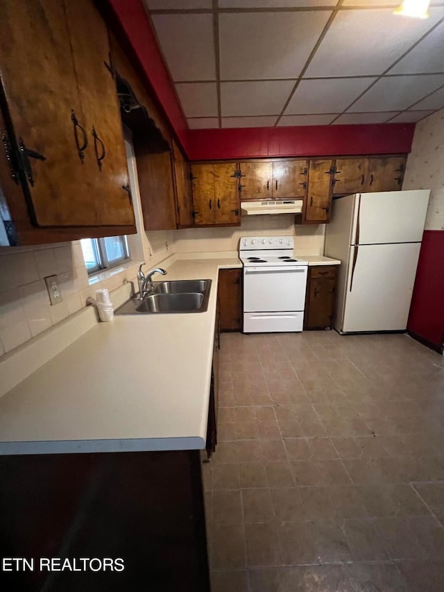 kitchen featuring white appliances, tasteful backsplash, a drop ceiling, and sink