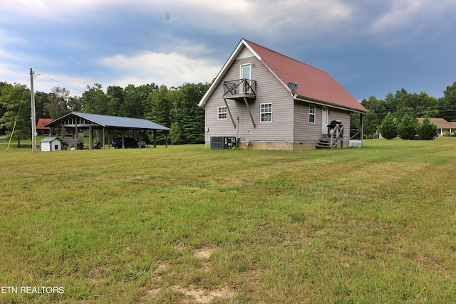 view of side of property with metal roof, crawl space, central AC unit, a detached carport, and a lawn