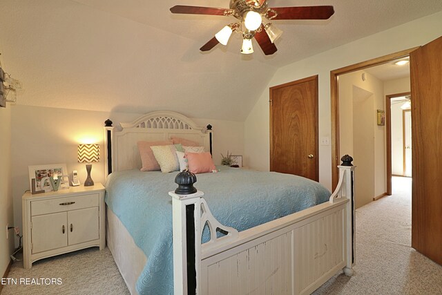 bedroom featuring light carpet, vaulted ceiling, a textured ceiling, and ceiling fan