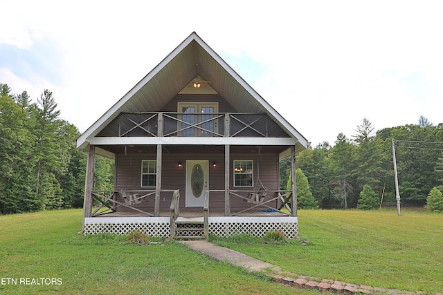 view of front of property featuring a balcony, a porch, and a front yard