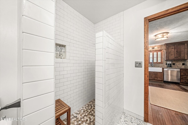 bathroom featuring hardwood / wood-style floors, tiled shower, a textured ceiling, and vanity