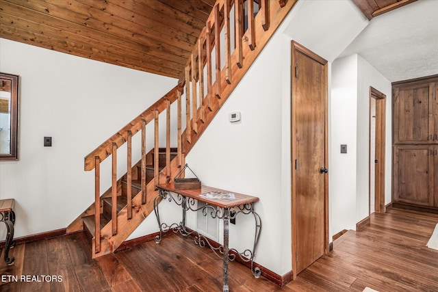 stairs featuring vaulted ceiling, wood-type flooring, and wooden ceiling