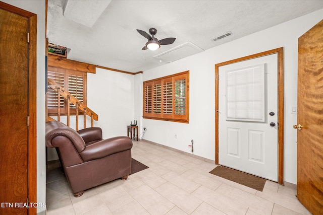 living room featuring ceiling fan and a textured ceiling