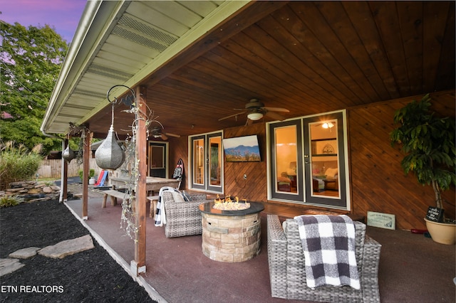 patio terrace at dusk featuring ceiling fan and french doors