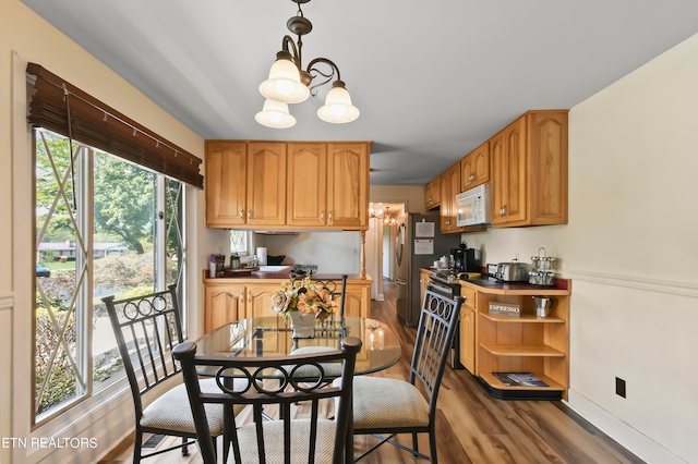 kitchen with hanging light fixtures, dark hardwood / wood-style flooring, a notable chandelier, stainless steel fridge, and range