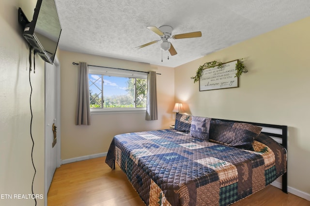 bedroom featuring ceiling fan, a textured ceiling, and light hardwood / wood-style flooring