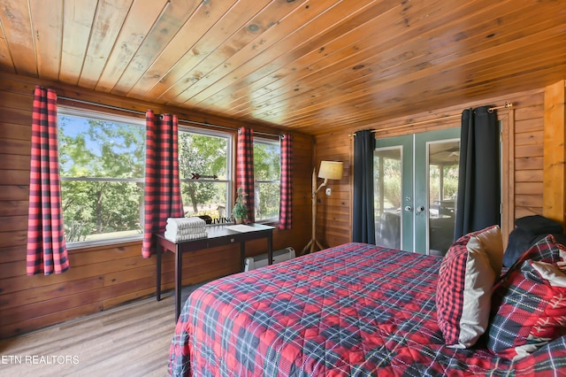 bedroom with wood ceiling, wooden walls, french doors, and wood-type flooring