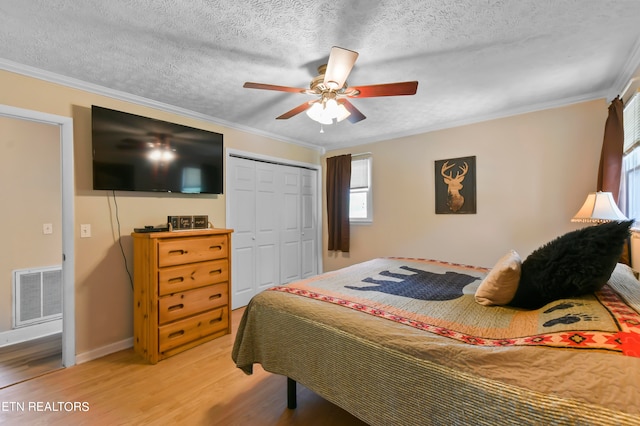 bedroom with hardwood / wood-style floors, ceiling fan, a closet, and multiple windows