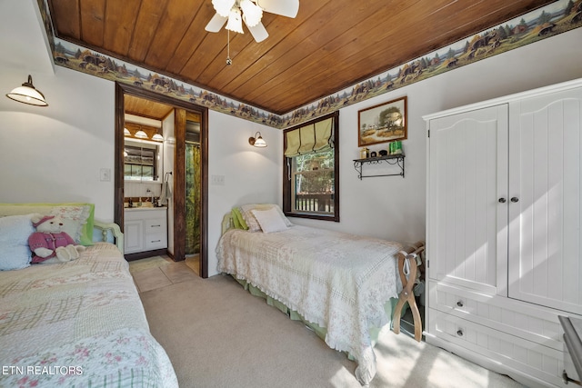 carpeted bedroom with wooden ceiling, connected bathroom, and ceiling fan