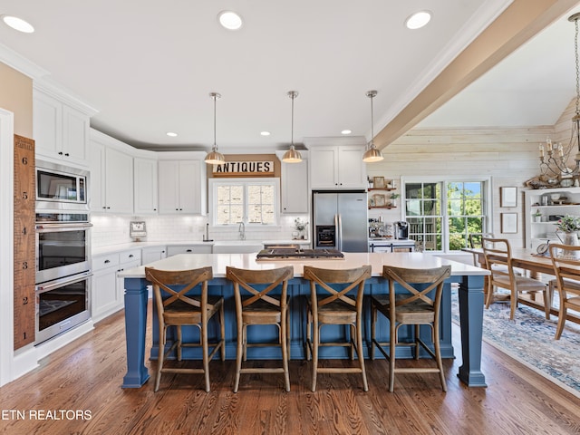 kitchen featuring pendant lighting, plenty of natural light, stainless steel appliances, and dark hardwood / wood-style floors