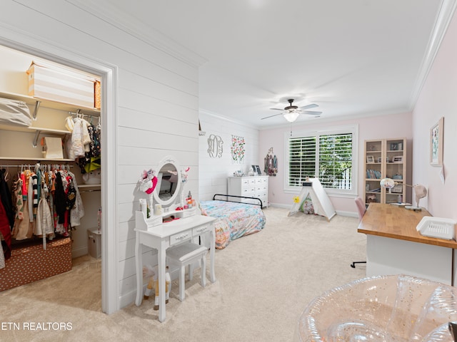 bedroom with a closet, light colored carpet, crown molding, and ceiling fan