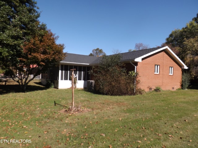 view of side of property with a lawn and a sunroom