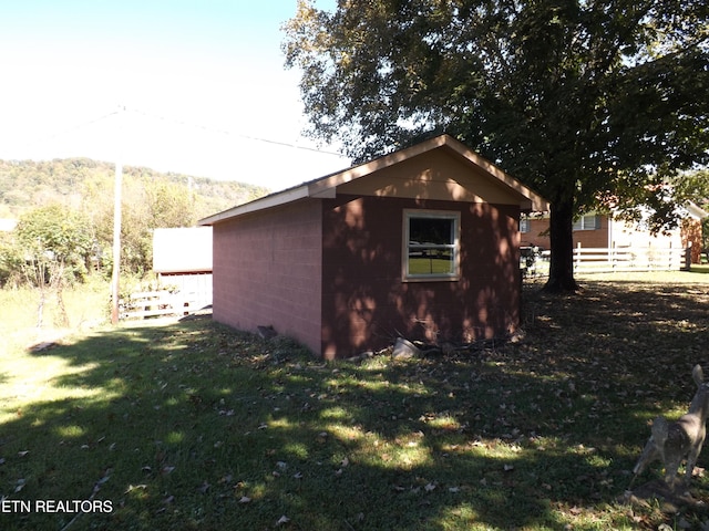 view of side of property with a storage unit and a yard