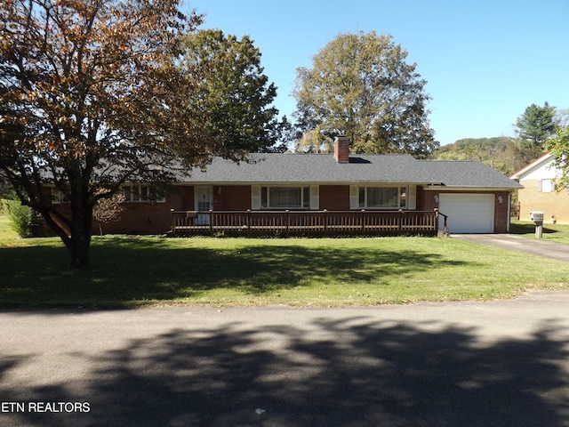 ranch-style house with covered porch, a front yard, and a garage