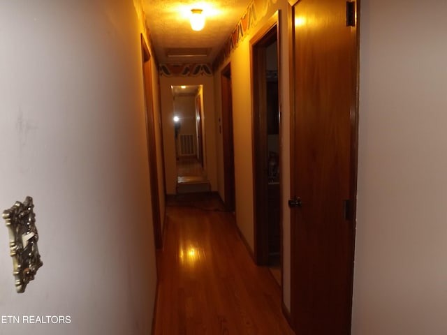 corridor with hardwood / wood-style floors