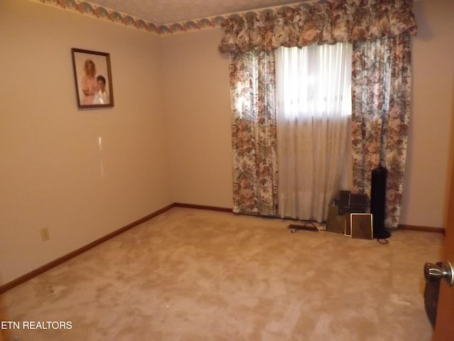 carpeted spare room with a wood stove